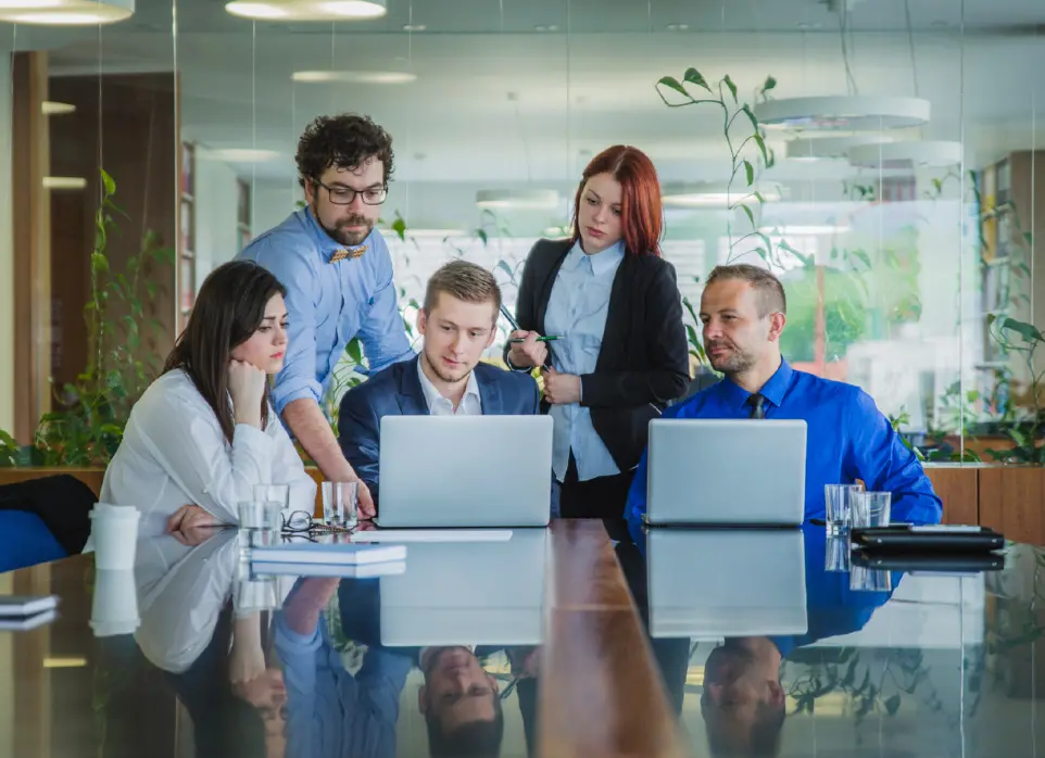 grupo de personas en la oficina observando los computadores