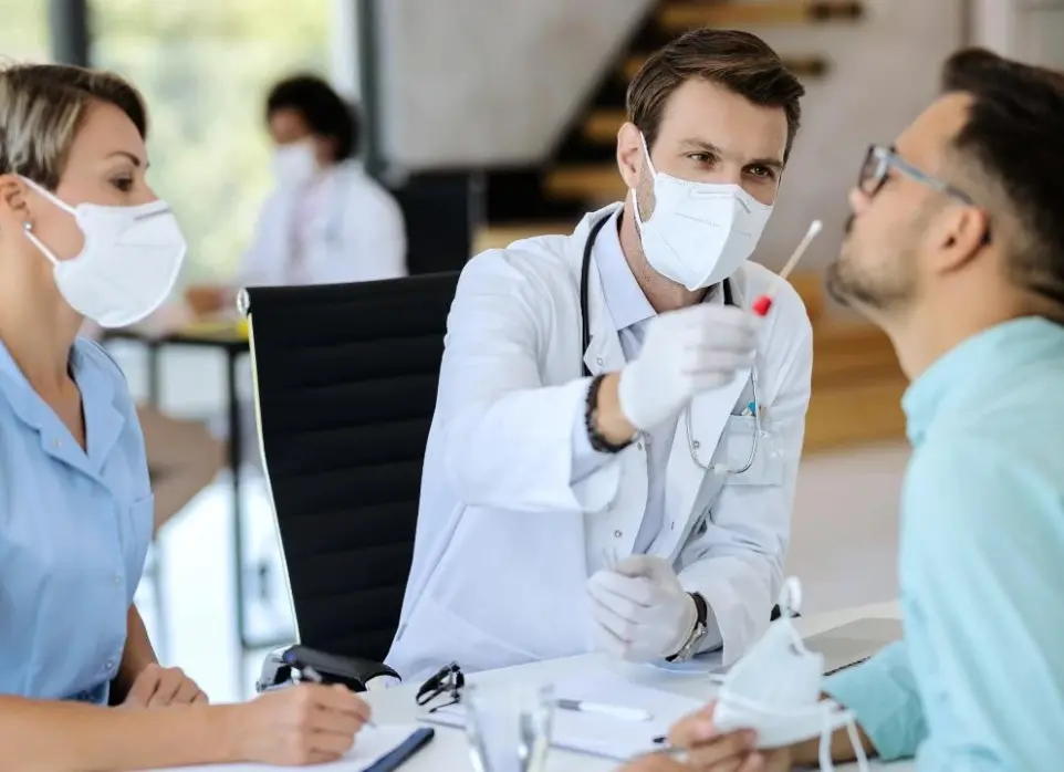 medico y enfermera haciendo prueba de covid a paciente