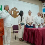 Hombre pronunciando un discurso en un podio de la UPC frente a una mesa de honor durante una ceremonia institucional.